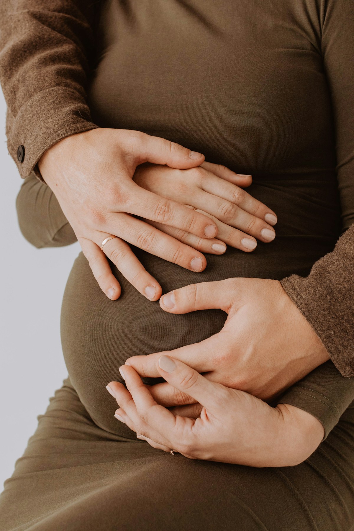 An expectant mother resting her hands on her belly